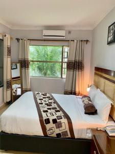 a bedroom with a large bed with a window at Dolar Lodges & Tours in Maun