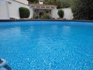 a large blue swimming pool in front of a house at One Life Málaga Retreat in Periana