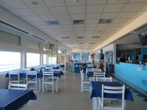 un restaurante con mesas azules y sillas blancas en Hotel Apartamento Praia Azul en Silveira