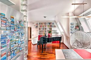 un soggiorno con pianoforte a coda e biblioteca di A casa di DiGi - Appartment at last floor with panoramic view ad Albano Laziale