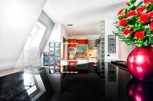 a kitchen with a large red vase with flowers in it at A casa di DiGi - Appartment at last floor with panoramic view in Albano Laziale