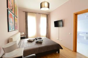 a bedroom with a bed with a chair and a television at Pensiunea Elphin in Târgu-Mureş