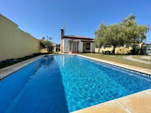 - une piscine en face d'une maison dans l'établissement Chalet Pura Vida, à Chiclana de la Frontera