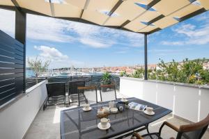 een patio met een tafel en stoelen op een balkon bij Apartments and Rooms Mare in Vodice