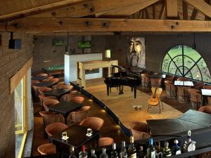 een kamer met een piano en een stel tafels en stoelen bij Hotel El Remanso Tapalpa in Tapalpa