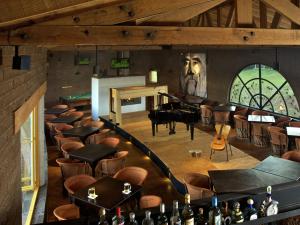 a room with a piano and a bunch of tables and chairs at Hotel El Remanso Tapalpa in Tapalpa