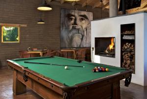 a room with a pool table and a painting of a man at Hotel El Remanso Tapalpa in Tapalpa