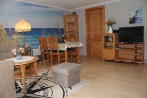 a living room with a table and chairs and a television at Wohnen unter dem Rohrdach in Zempin +11 photos