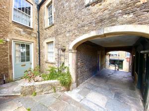 an entrance to a brick building with an archway at Cosy Weavers Cottage - Heart of Frome in Frome