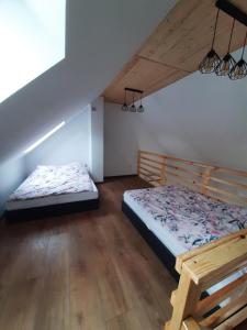 een slaapkamer met 2 bedden op een zolder bij Agroturystyka Kluki u Tosi in Smołdzino