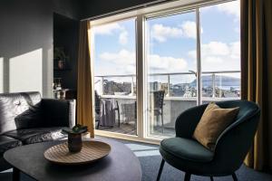a living room with a chair and a table and a large window at 62N Hotel - City Center in Tórshavn