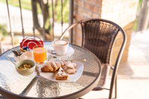 アリアーノ・テルメにあるAgriturismo "Le Giustizie"の食べ物の皿とコーヒーカップが置かれたテーブル