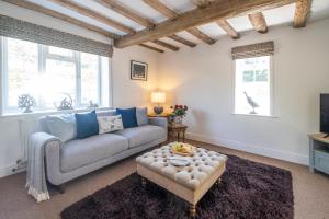 a living room with a couch and a table at Laurel Cottage - Aldeburgh Coastal Cottages in Blyford