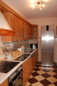 uma cozinha com armários de madeira e um frigorífico de aço inoxidável em Apartament Jawornik em Wisla