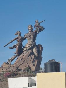 a statue of people on top of a rock at Mini Studio au rez de chaussée in Ouakam
