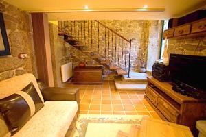a living room with a staircase in a stone building at 5 bedrooms house with lake view private pool and garden at Cuntis in Cuntis