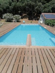 una gran piscina en la parte superior de una terraza de madera en Gîtes Carbuccia en Corse avec piscine chauffée en Carbuccia