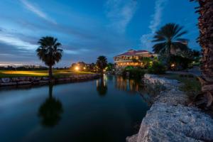 a river with a building and palm trees at night at All Inclusive - Divi Village Golf and Beach Resort in Palm-Eagle Beach