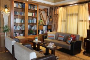 a living room with a couch and tables and bookshelves at Park Hotel Polykastro in Polýkastron