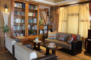 a living room with a couch and tables and bookshelves at Park Hotel Polykastro in Polykastro