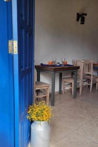 Sítio Juara في سانتا تيريزا: غرفة طعام مع طاولة و مزهرية مع الزهور