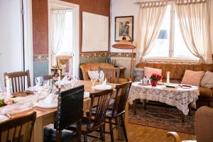 Un comedor con una mesa larga y sillas. en Skotteksgården Cottages, en Ulricehamn