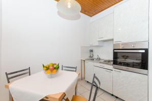 House Petar في راتشيتشيه: مطبخ مع طاولة عليها صحن من الفواكه