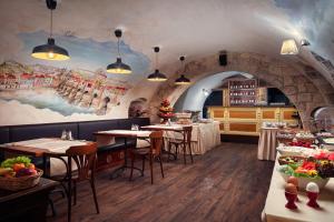 a restaurant with tables and chairs and a painting on the wall at The Charles in Prague