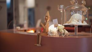 a figurine of a person sitting on a counter with a glass jar at Hotel Pinocchio in Cattolica