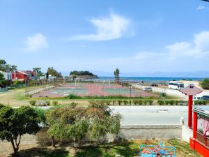 a tennis court in a park next to the ocean at Anna Garden Sidari in Sidari