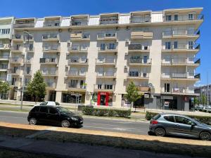 two cars parked in front of a large building at KENZA jednosobni stanovi in Podgorica