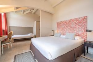 a bedroom with a large bed and a desk at Spinerola Hotel in Cascina & Restaurant UvaSpina in Moncalvo