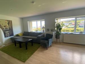 uma sala de estar com um sofá e uma mesa em Hyggelig lejlighed ved åen - flot udsigt em Tórshavn