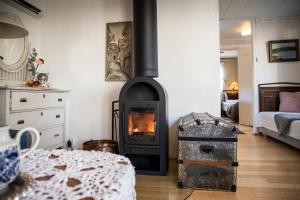 una sala de estar con estufa de leña. en Skotteksgården Cottages, en Ulricehamn