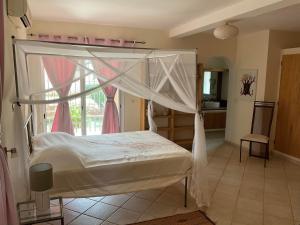 - une chambre avec un lit à baldaquin dans l'établissement La Maison de Jeanne et Léa, à La Somone