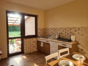 a kitchen with a table and a sink and a window at Agroturystyka Sosnowy Gaik in Tykocin