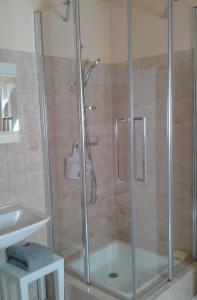 a shower with a glass door in a bathroom at Au Guildo, proche GR34 in Notre-Dame-du-Guildo