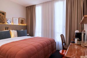 une chambre d'hôtel avec un lit, une table et une fenêtre dans l'établissement Hotel Dadou Paris, à Paris