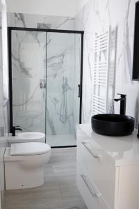 e bagno bianco con servizi igienici e doccia in vetro. di Villa Costantino a Pompei