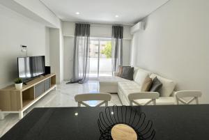 a living room with a couch and a tv at Aman - Near the beach by HD PROPERTIES in Cavacos