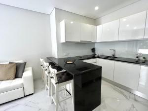 a kitchen with a black counter and white cabinets at Aman - Near the beach by HD PROPERTIES in Cavacos