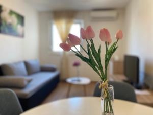 a vase with pink flowers sitting on a table at Apartment Sućidar in Split