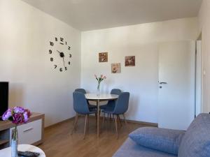a living room with a table and chairs and a clock at Apartment Sućidar in Split