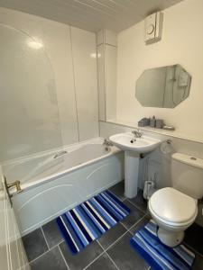 a bathroom with a tub and a sink and a toilet at Pure Apartments Dunfermline East - Dalgety Bay in Saint Davids