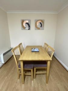 una mesa de madera y 2 sillas en una habitación en Pure Apartments Dunfermline East - Dalgety Bay, en Saint Davids