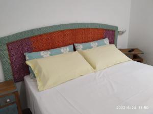 a bed with two pillows on top of it at B&B SA CROBE in Lanusei