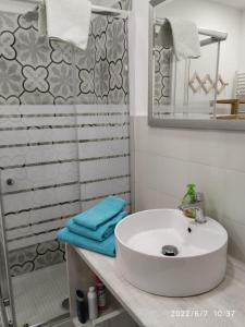 uma casa de banho com um lavatório branco e um chuveiro em B&B SA CROBE em Lanusei