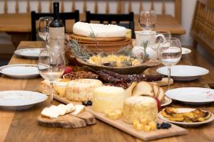 a table topped with cheese and wine glasses at SOBE NA FARMI 