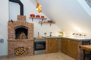 a kitchen with a brick fireplace in a loft at SOBE NA FARMI 