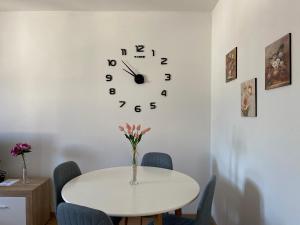 a table with chairs and a clock on a wall at Apartment Sućidar in Split